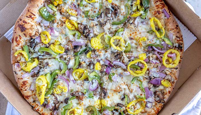 Cousin Vinny's Chicken Formaggio Pizza in Kettering is topped with white American Swiss cheese, chicken, red onion, green pepper, mushroom, and banana pepper